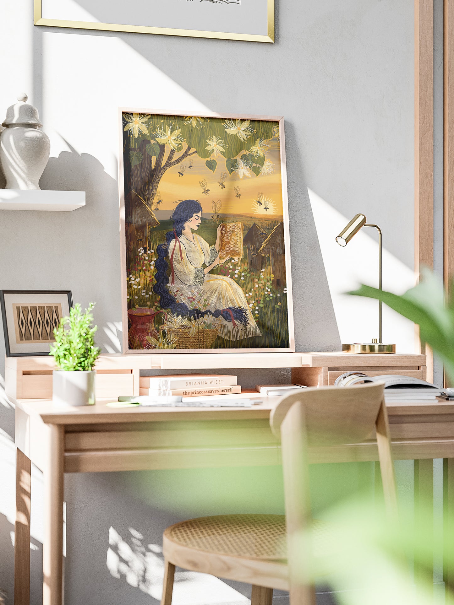Wydruk artystyczny „Kraina miodu" oprawiony w ramę na biurku w jasnym wnętrzu – dekoracja do gabinetu, folk art print Natalia Noszczyńska