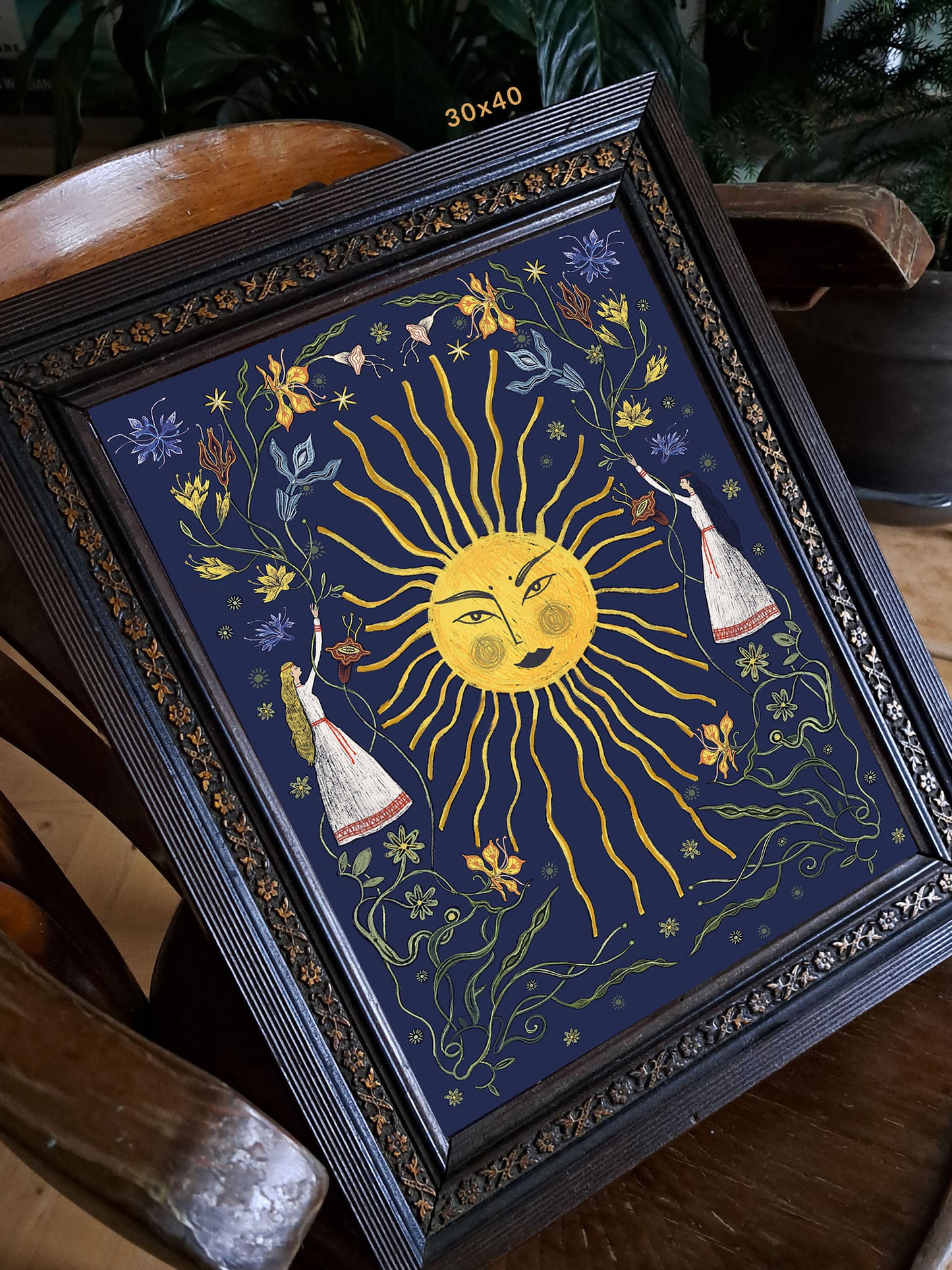 Wydruk „Letnie przesilenie granat" w ciemnej ozdobnej ramie 30×40 cm na drewnianym krześle – folk art print Natalii Noszczyńskiej, Black Dog Studio