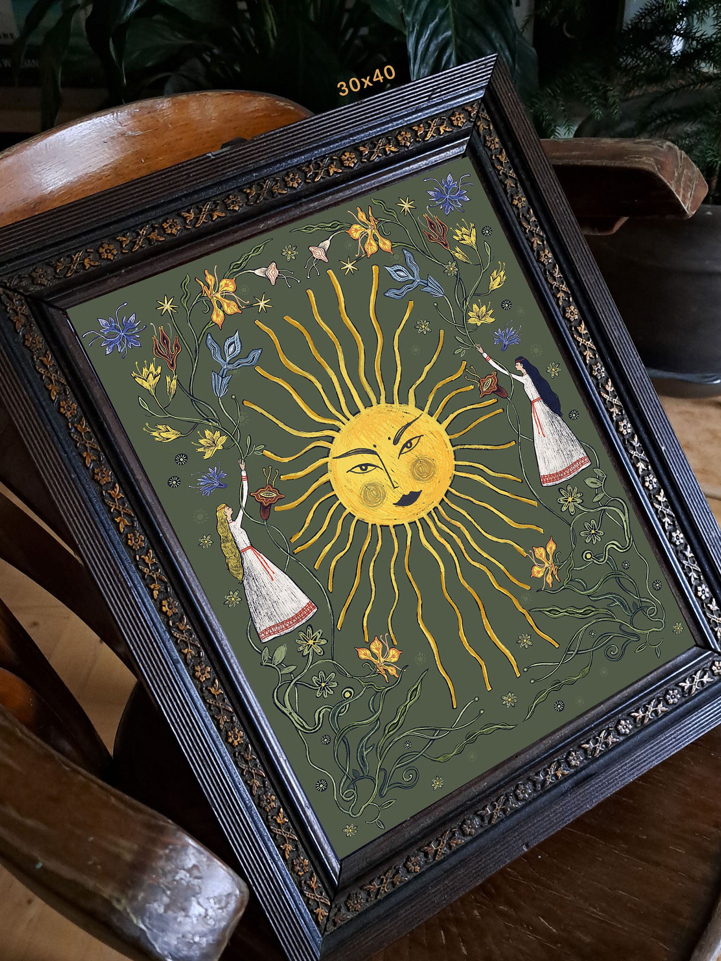 Wydruk artystyczny „Letnie przesilenie zieleń" w czarnej ramie opartej o białą ścianę – folk art print Natalii Noszczyńskiej, Black Dog Studio