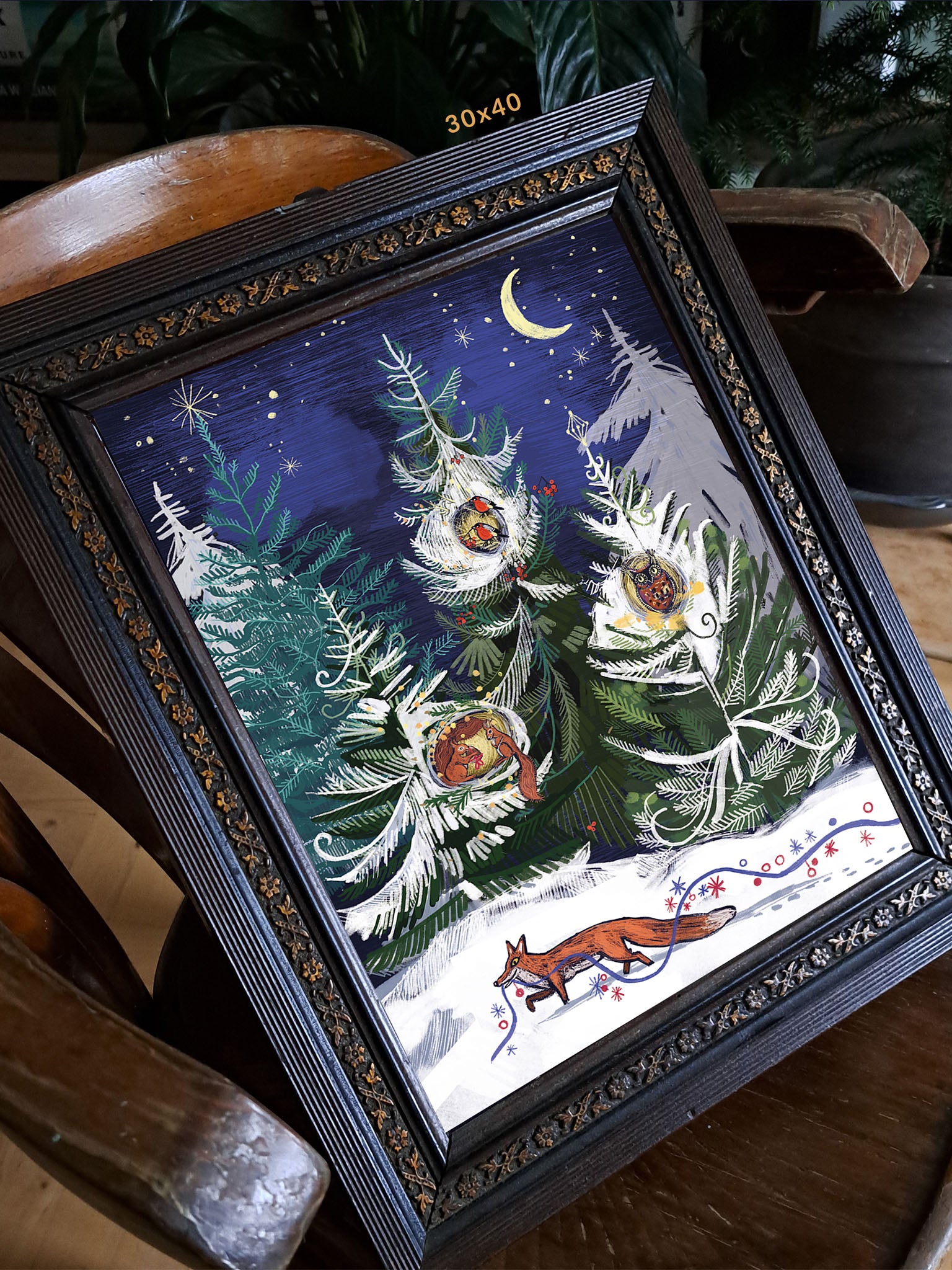 Ilustracja „Opowieści Wigilijne" Natalii Noszczyńskiej w ciemnej zdobionej ramie 30x40 cm – zimowy las z lisem, wiewiórką, gilem i sową w gniazdach wśród świerków